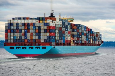A large container cargo ship sailing on the ocean, fully loaded with colorful shipping containers, symbolizing global ocean freight, FCL, and LCL shipping solutions.